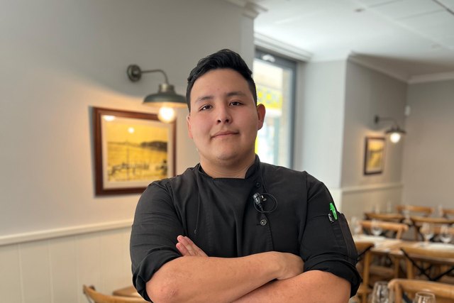 Dante Andrade poses in a chef jacket in the Casa Román dining room.